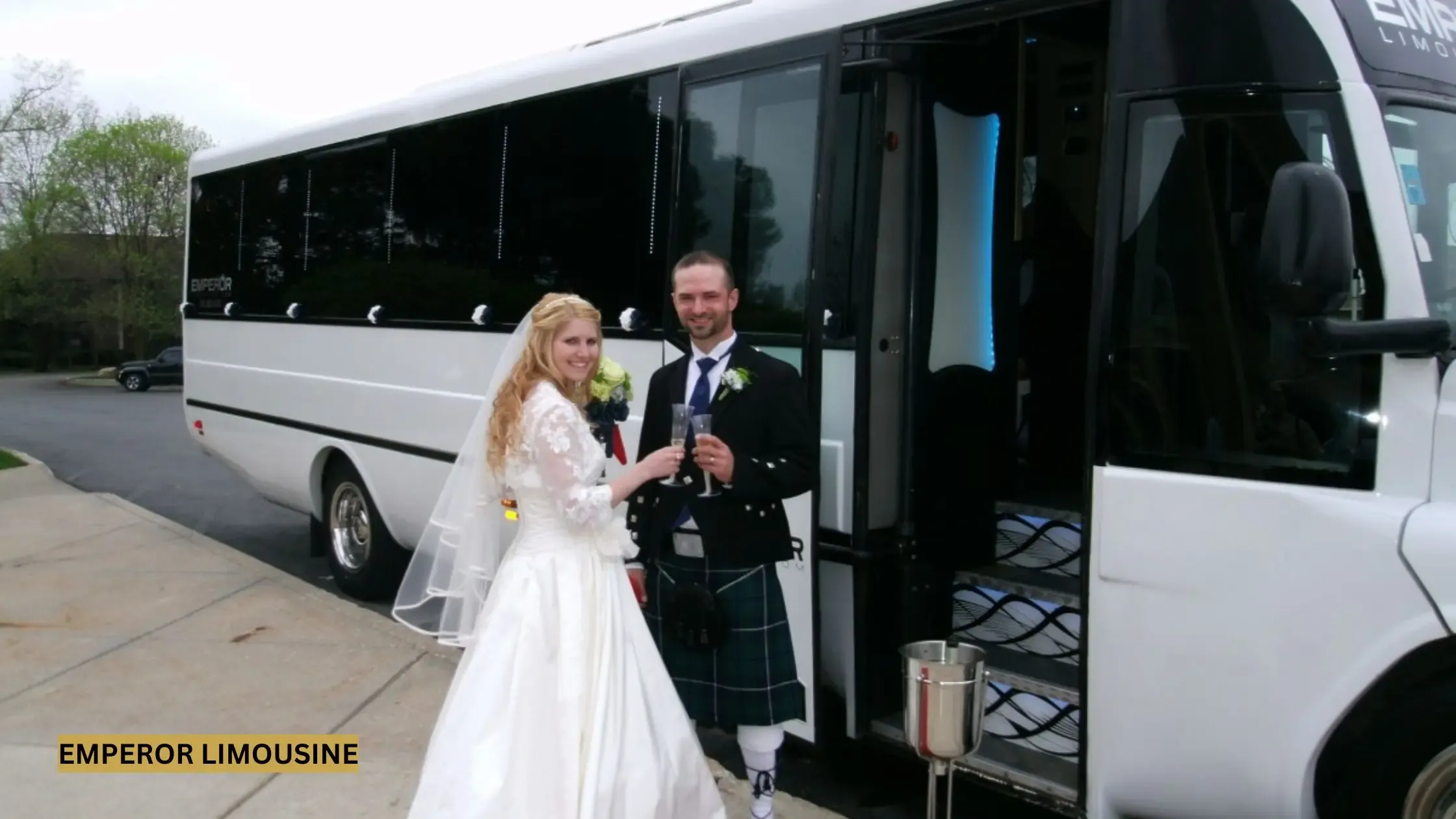 Newlywed couple in front of a luxury limo bus